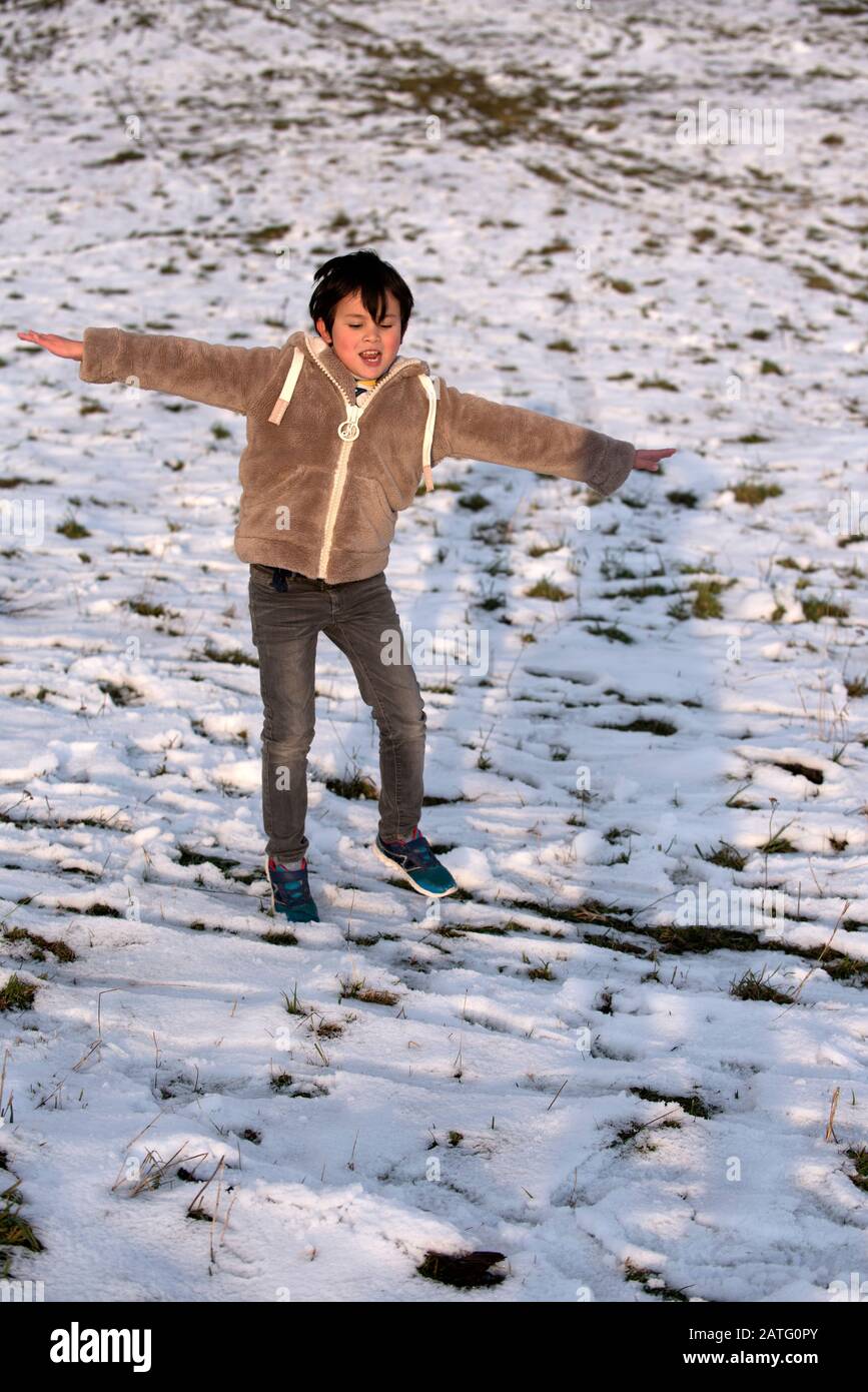 Child jumping on snow Stock Photo