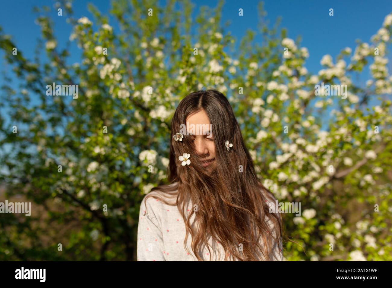 Portrait of a young beautiful teenager girl in a blooming spring green ...