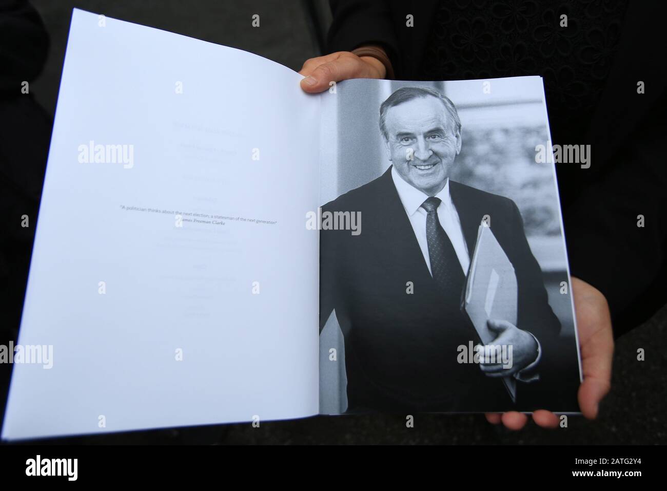 A Lady Holds Open A Mass Booklet During The Funeral Of The Fomer