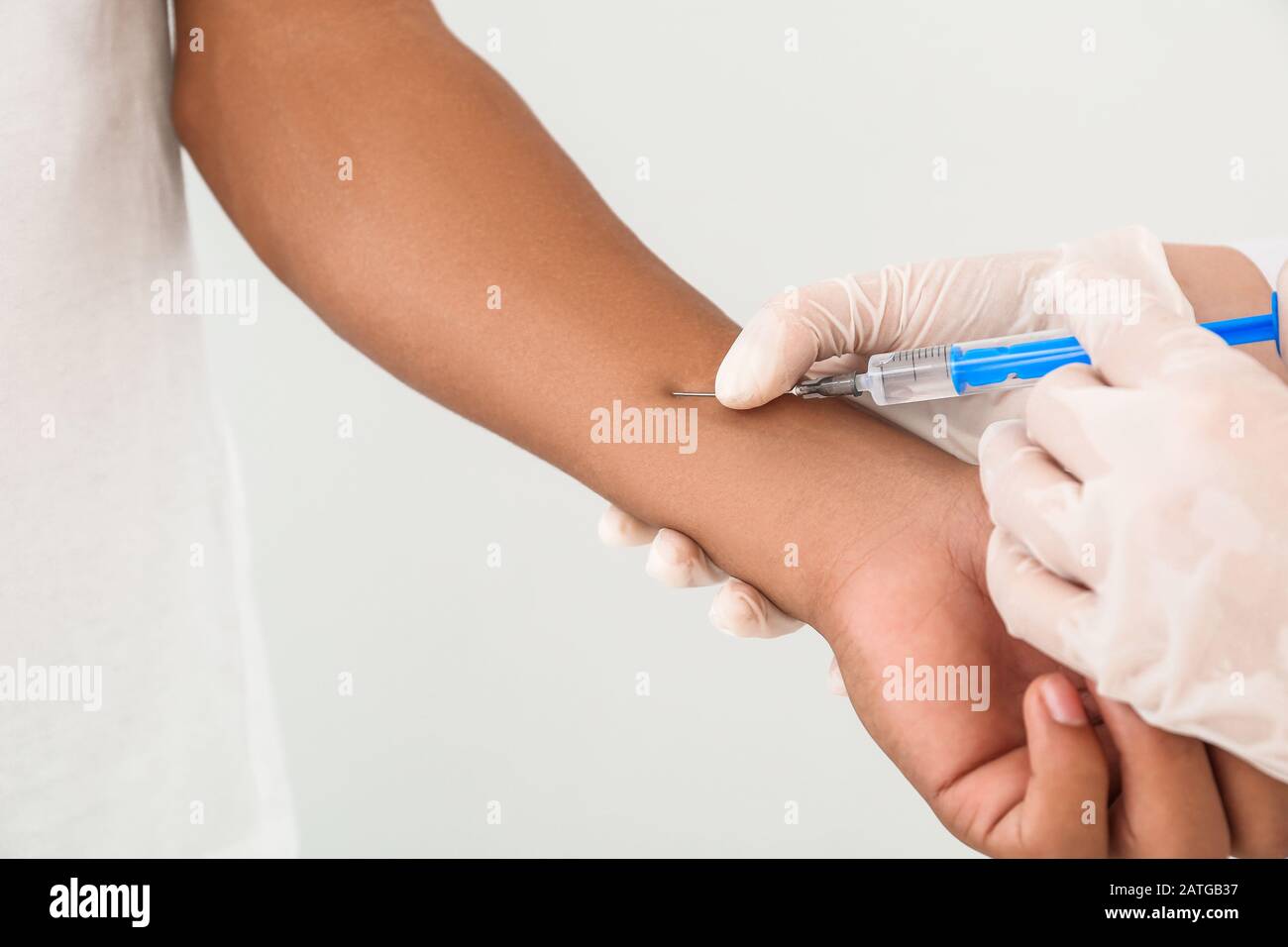 Female doctor conducting Mantoux test against light background Stock Photo