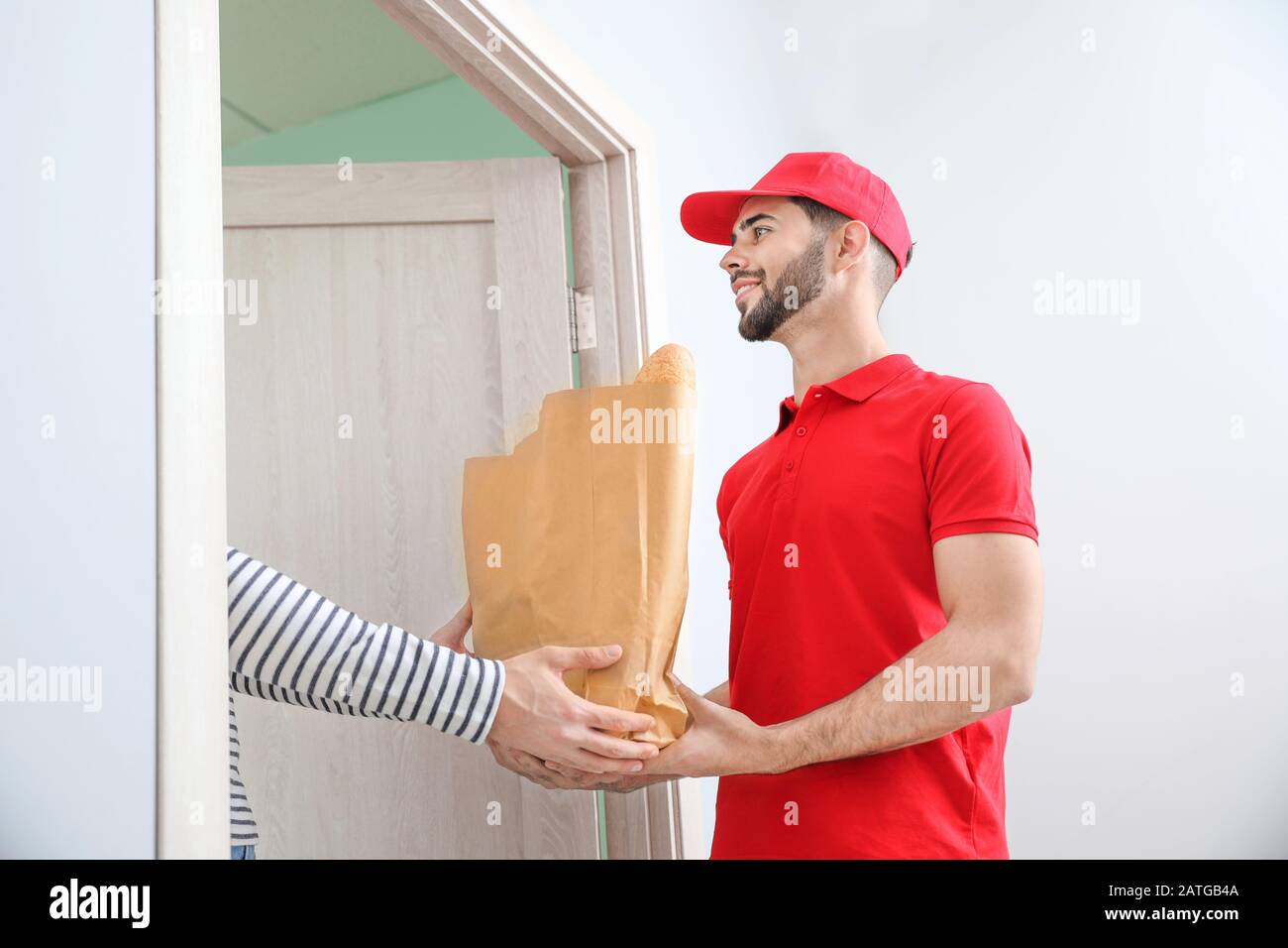 Man receiving order from courier of food delivery company Stock Photo