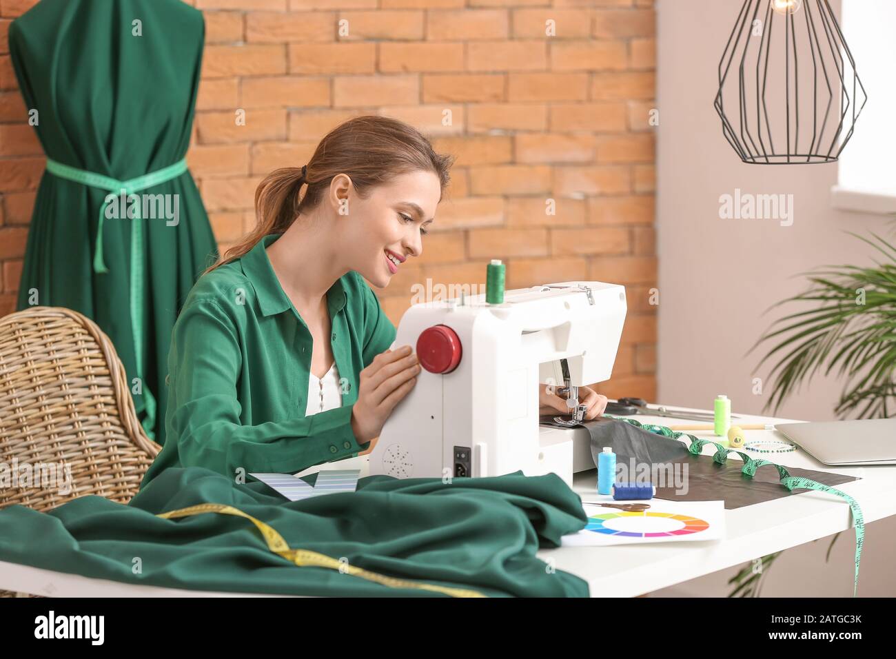 Young woman sewing clothes in atelier Stock Photo - Alamy