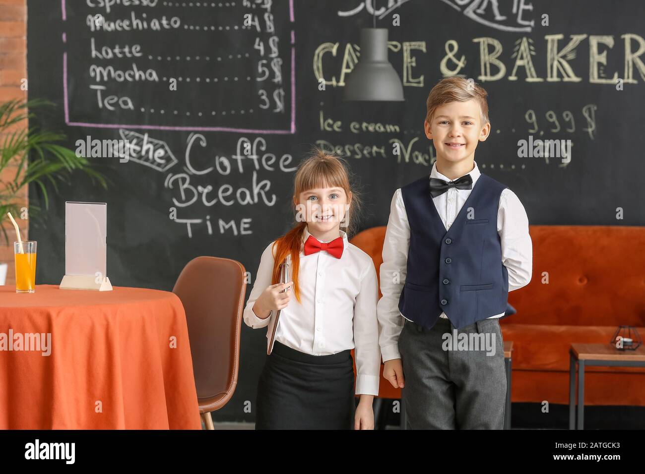Cute little waiters in restaurant Stock Photo - Alamy