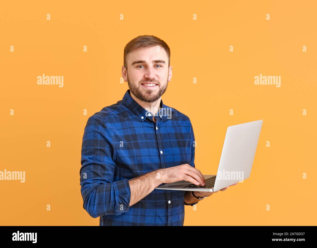 Male programmer with laptop on color background Stock Photo