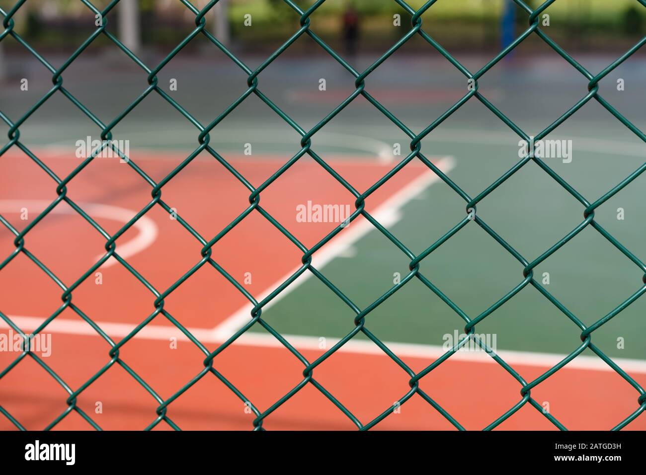 outdoor basketball court behind a metal fence horizontal composition