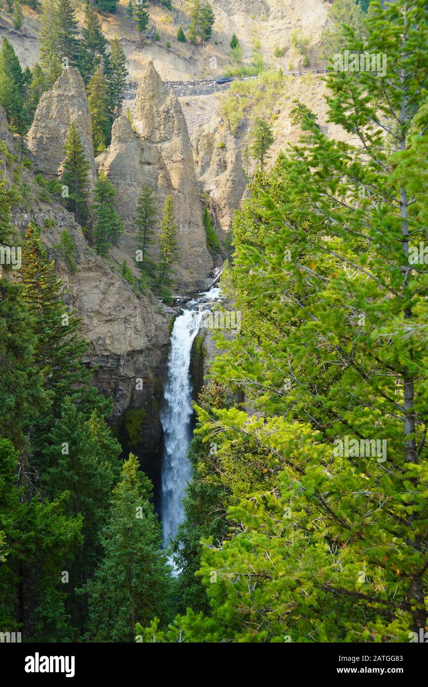 The impressive Tower Falls in Yellowstone National Park shares the landscape with hoodoos and beautiful foliage. Stock Photo