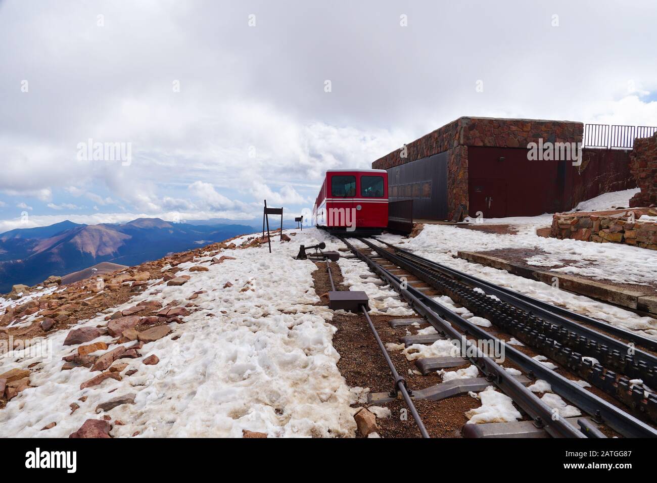 A mountain train is leaving the snow covered summit and heading back down. Stock Photo