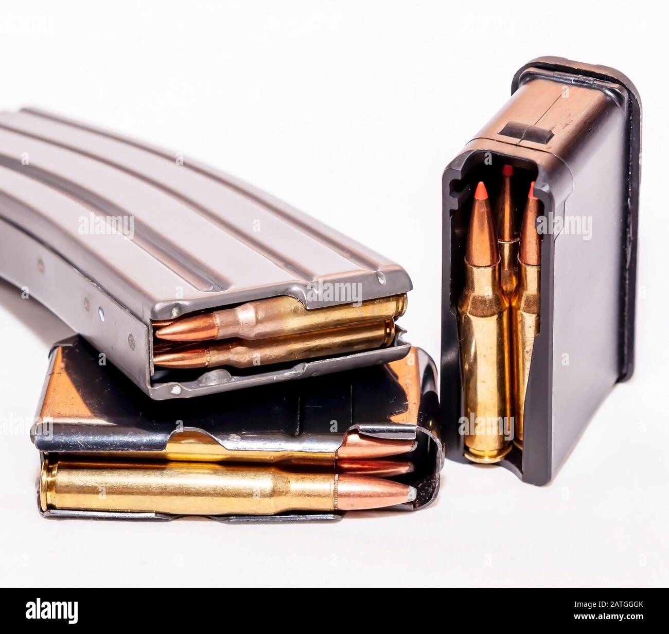 Three different caliber and size loaded rifle magazines on a white