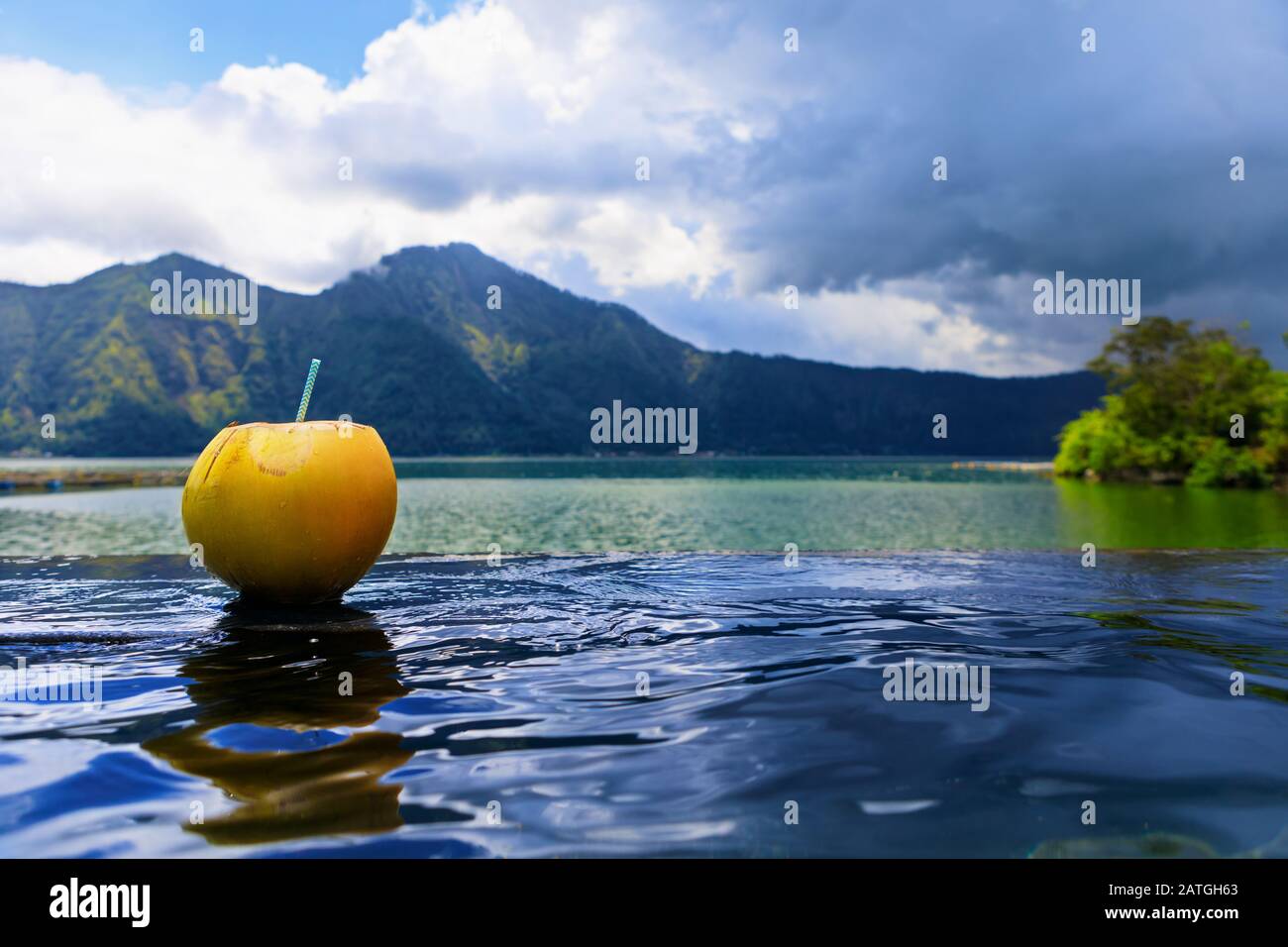 Natural hot spring spa beside Batur volcano. Hot water flow to infinity pool with beautiful lake and mountain Abang view. Popular travel destination Stock Photo