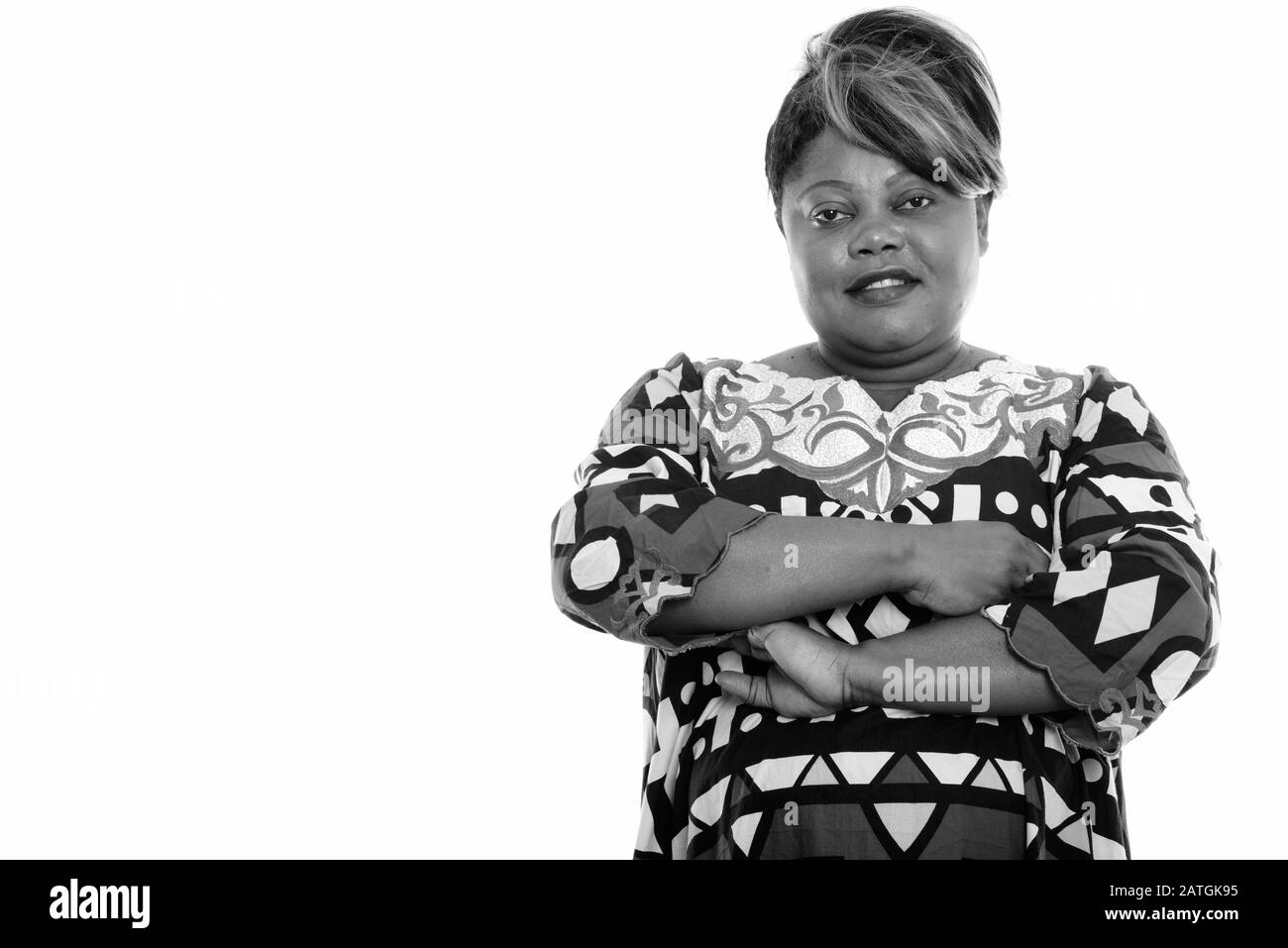 Studio shot of happy overweight African woman smiling with arms crossed ...