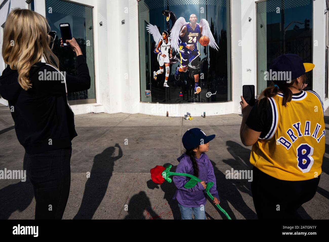 Los Angeles, United States. 02nd Feb, 2020. Kobe Bryant fans take pictures of an illustration of Bryant and his daughter during a makeshift memorial in honour of the former NBA star, Kobe Bryant, outside the Staples Center in Los Angeles.Kobe and his daughter Gianna were among the nine people who died in a helicopter crash. Credit: SOPA Images Limited/Alamy Live News Stock Photo