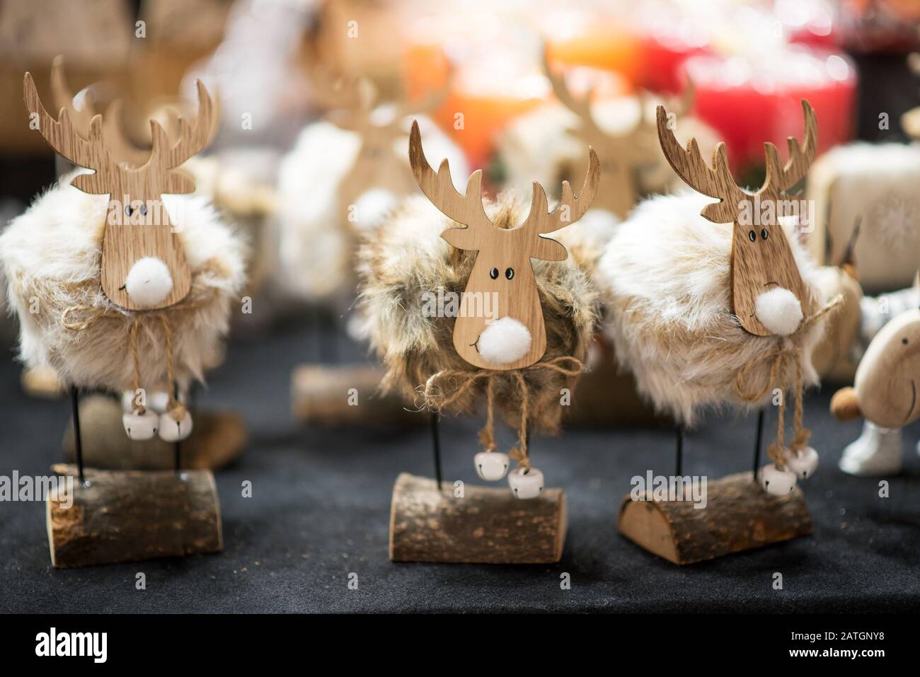 Handcrafted rustic wooden Christmas reindeer souvenirs and candles behind to celebrate the holiday season Stock Photo