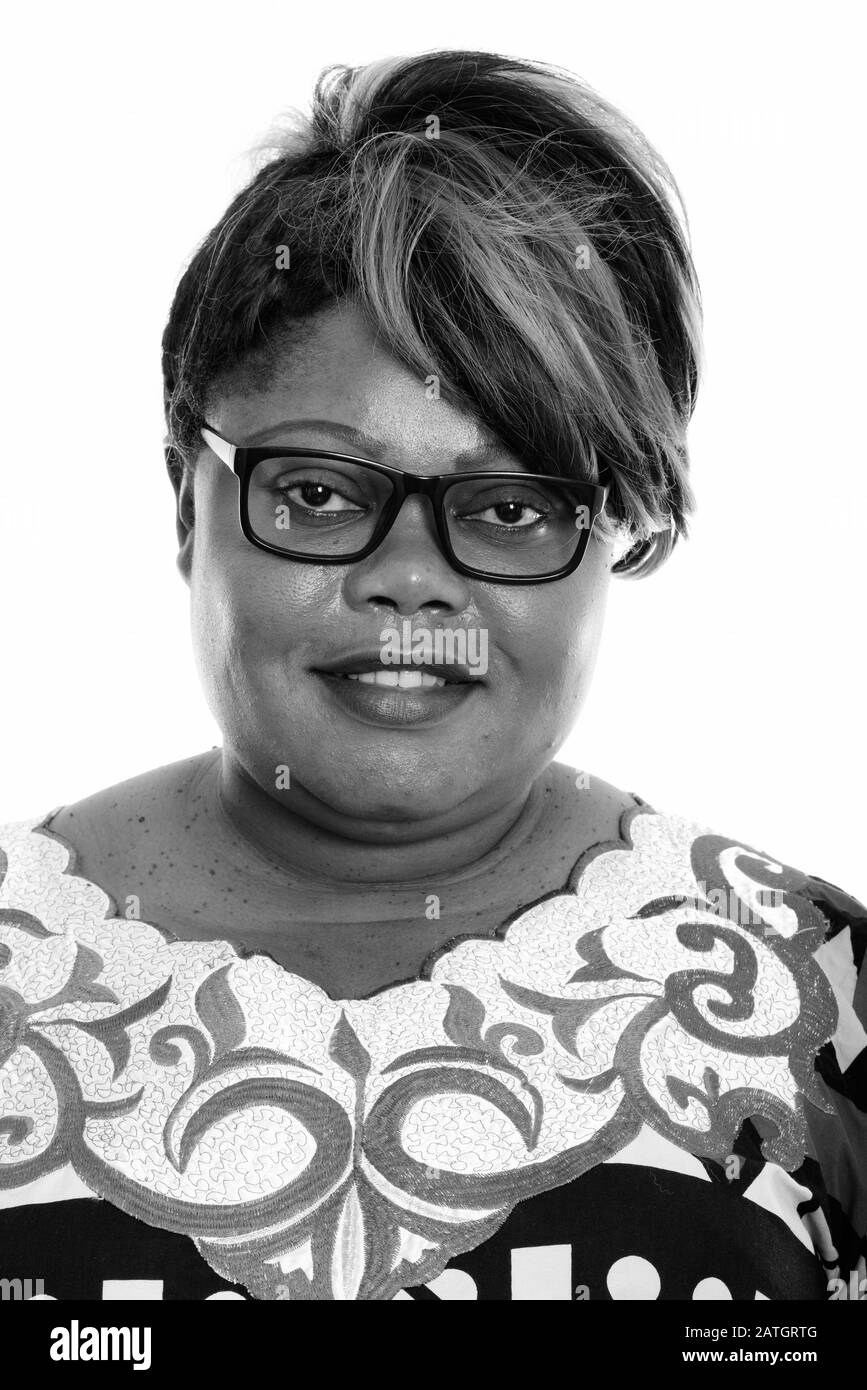 Face of happy fat black African woman smiling while wearing eyeglasses Stock Photo