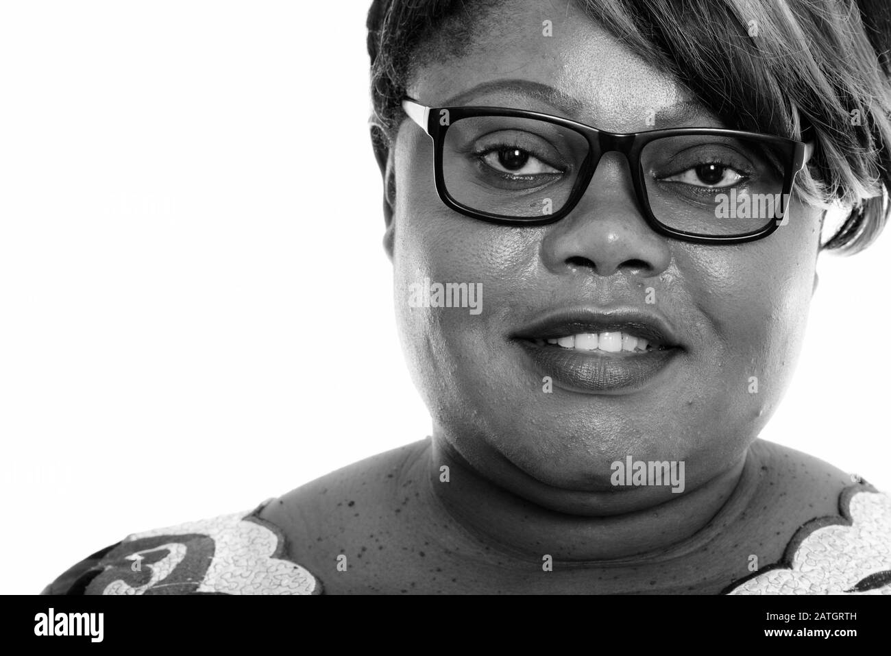 Close up of happy fat black African woman smiling while wearing eyeglasses Stock Photo