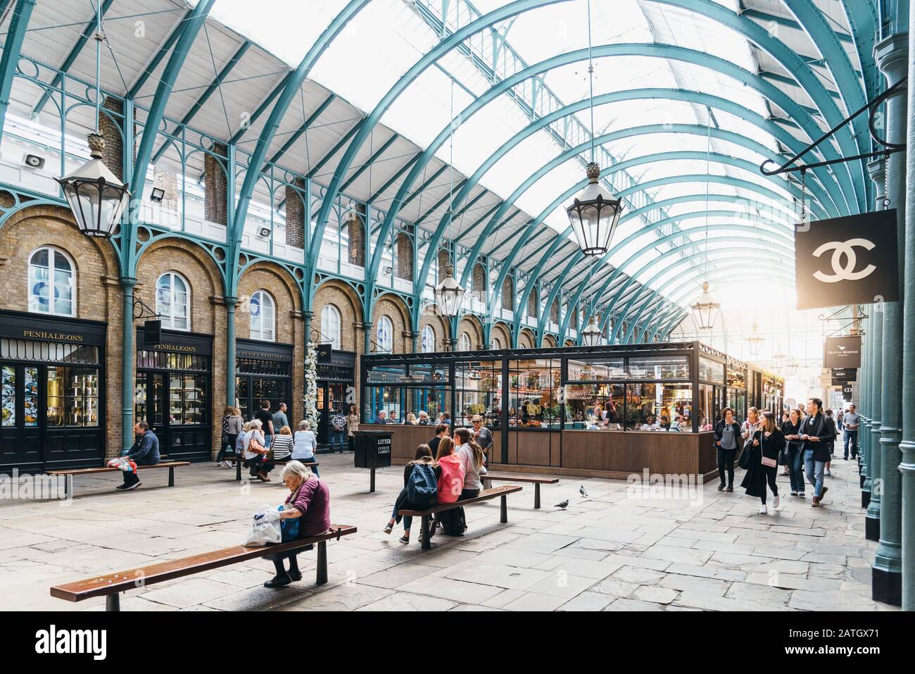 London, UK - May 15, 2019: People enjoying in Covent Garden Market, view with sunflare. Located in the West End of London, Covent Garden is renowned f Stock Photo