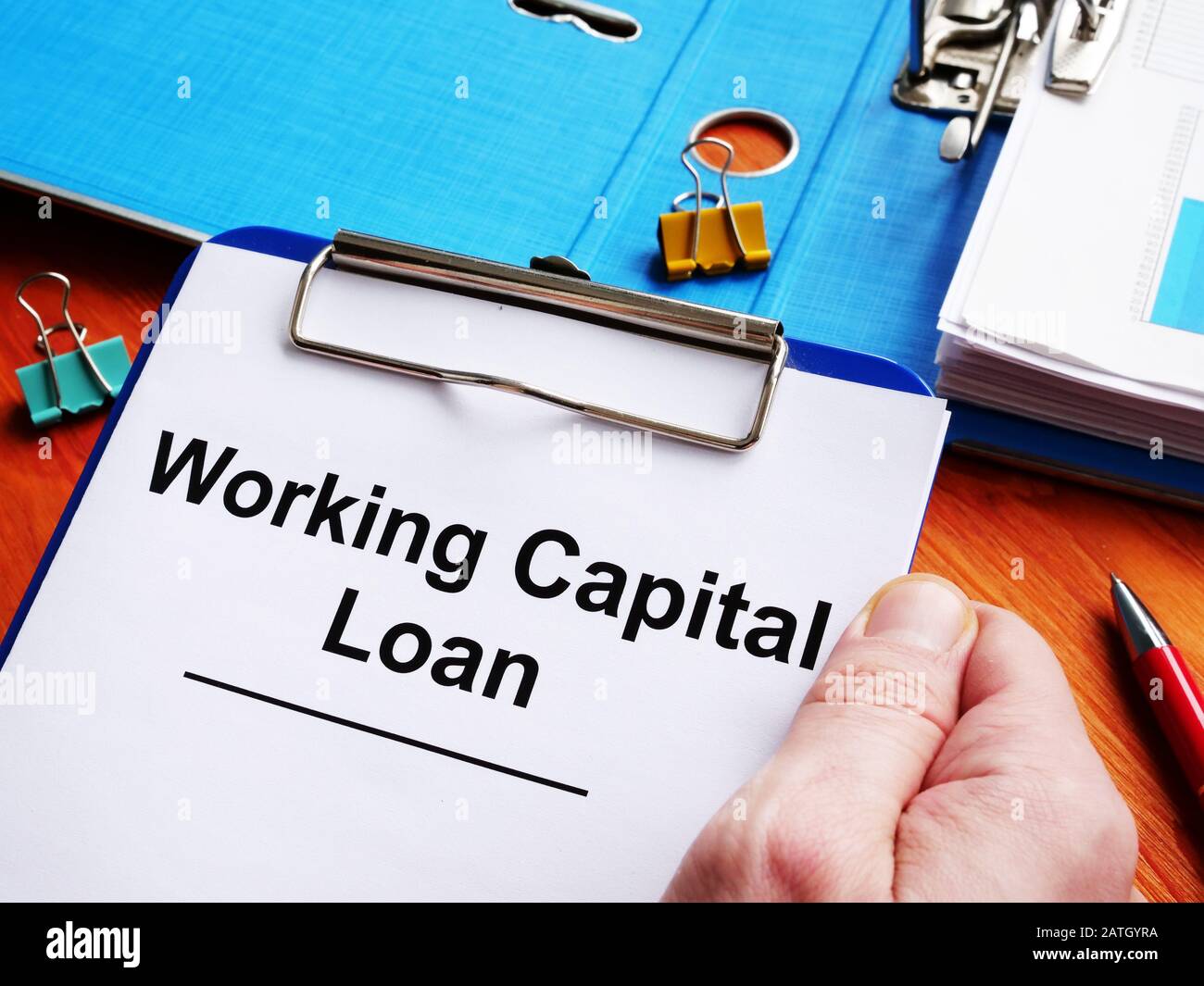 Man holds Working Capital Loan form for signing. Stock Photo