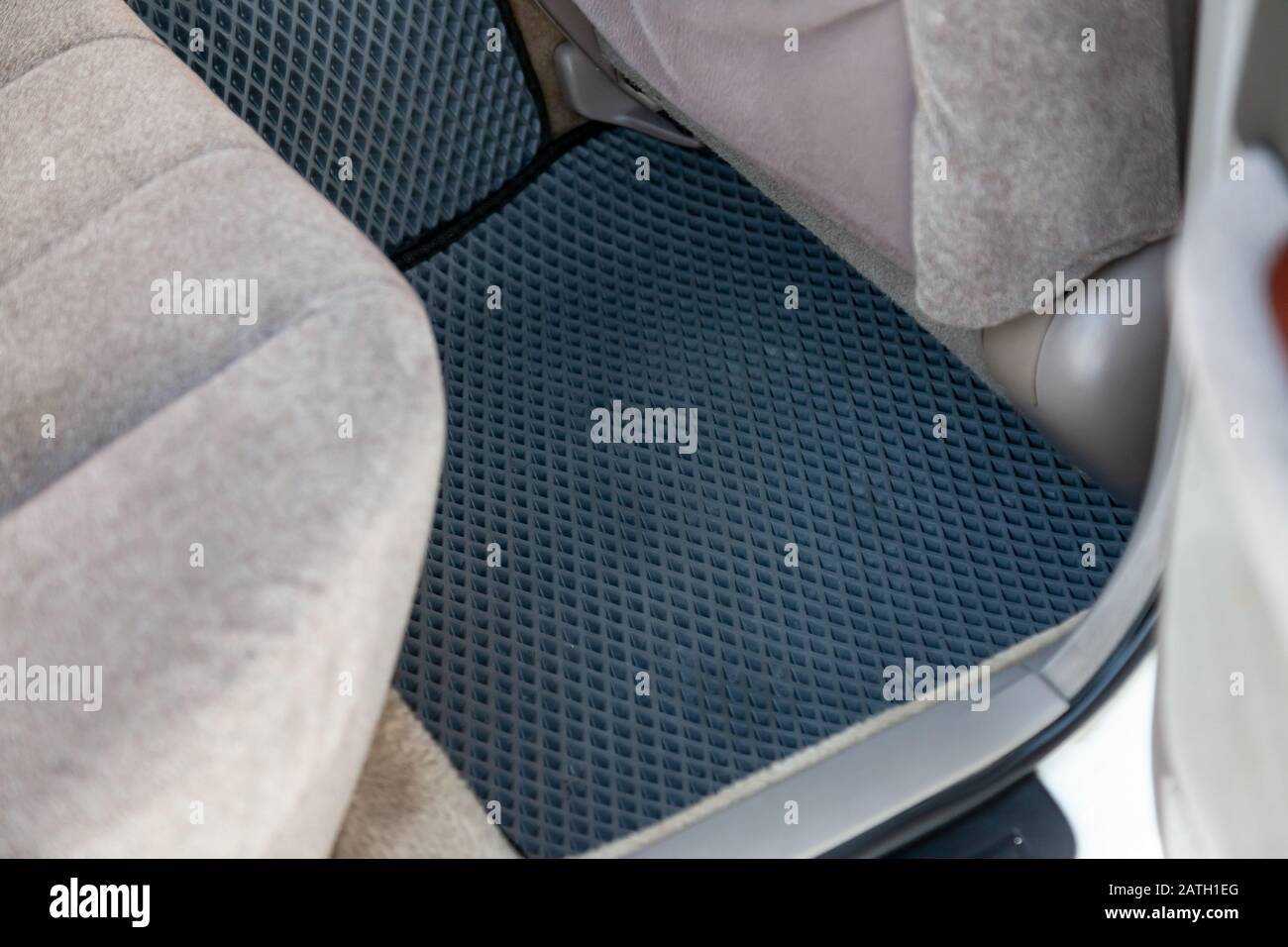 Clean car floor mats of black rubber under passenger seat in the
