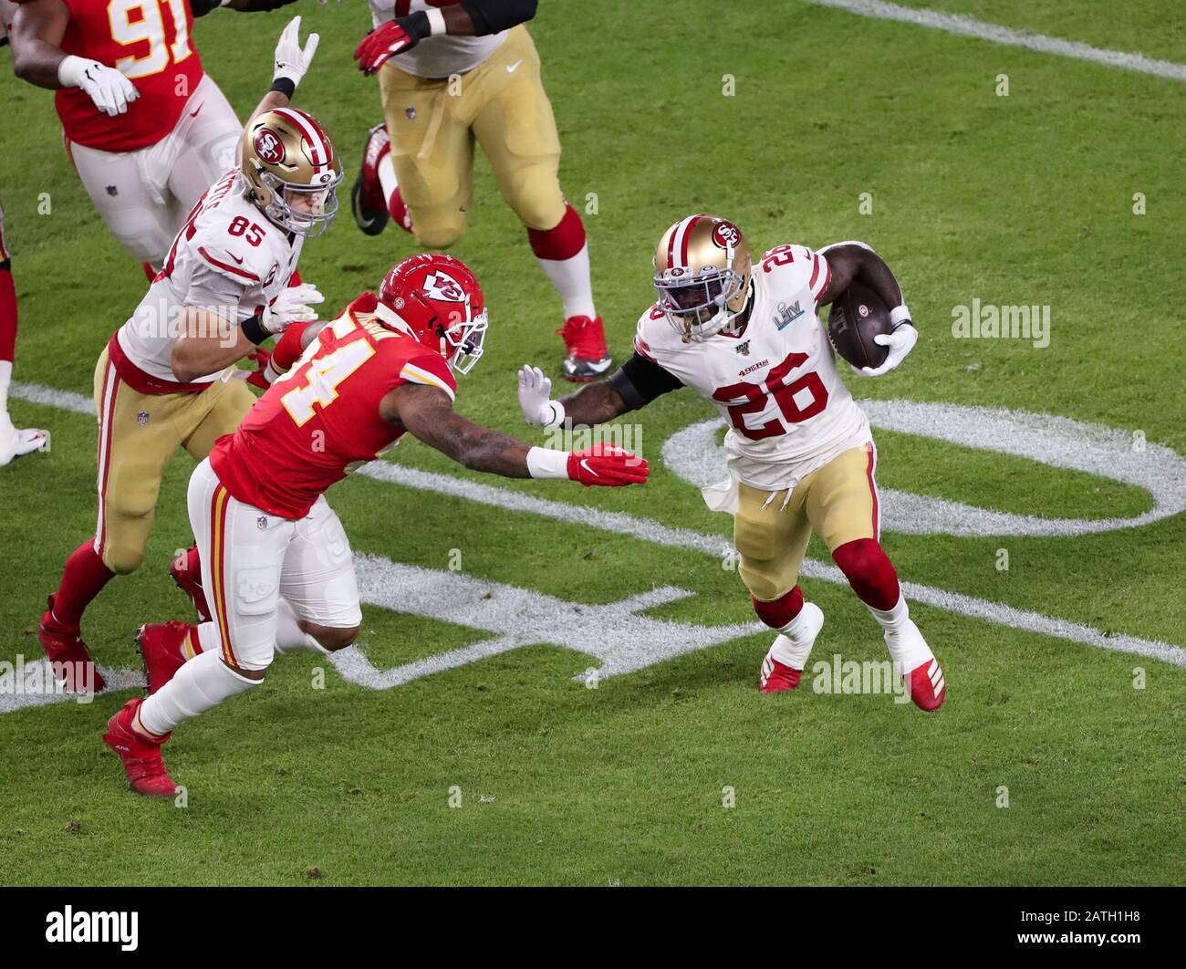 Miami Gardens, Florida, USA. 02nd Feb, 2020. San Francisco 49ers running back Tevin Coleman (26) runs with the ball pressured by Kansas City Chiefs outside linebacker Damien Wilson (54) during the Super Bowl LIV at the Hard Rock Stadium in Miami Gardens, Florida. Mario Houben/CSM/Alamy Live News Stock Photo
