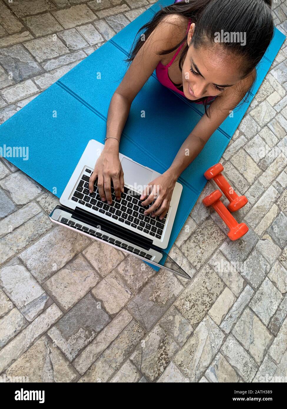 Latin girl exercising at home with a laptop, Panama, Central America Stock Photo