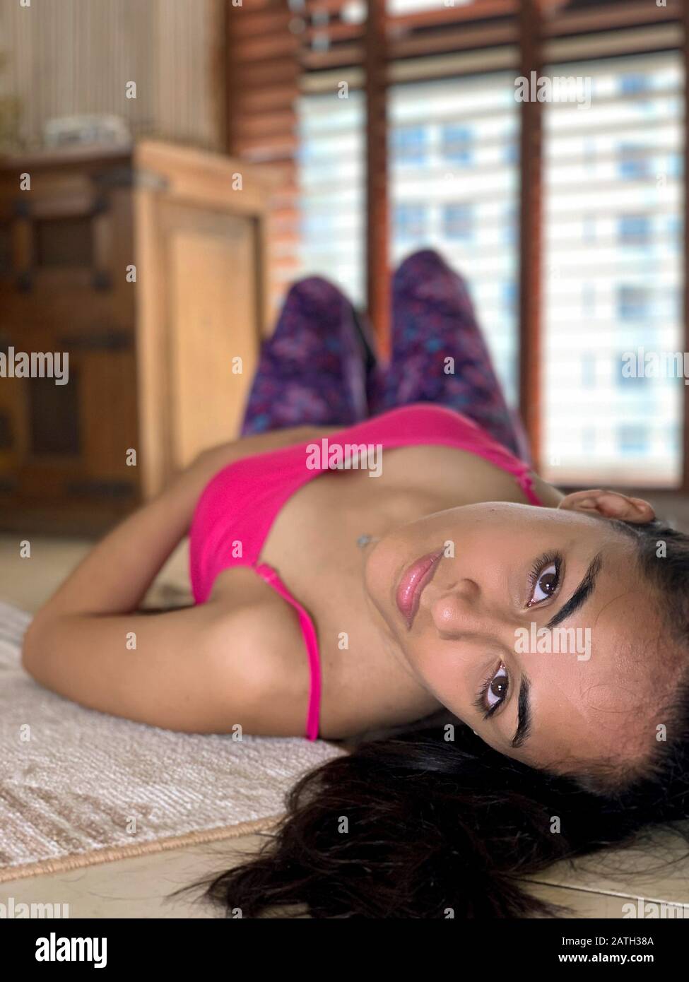 Portrait of happy latin young woman lying on the floor Stock Photo