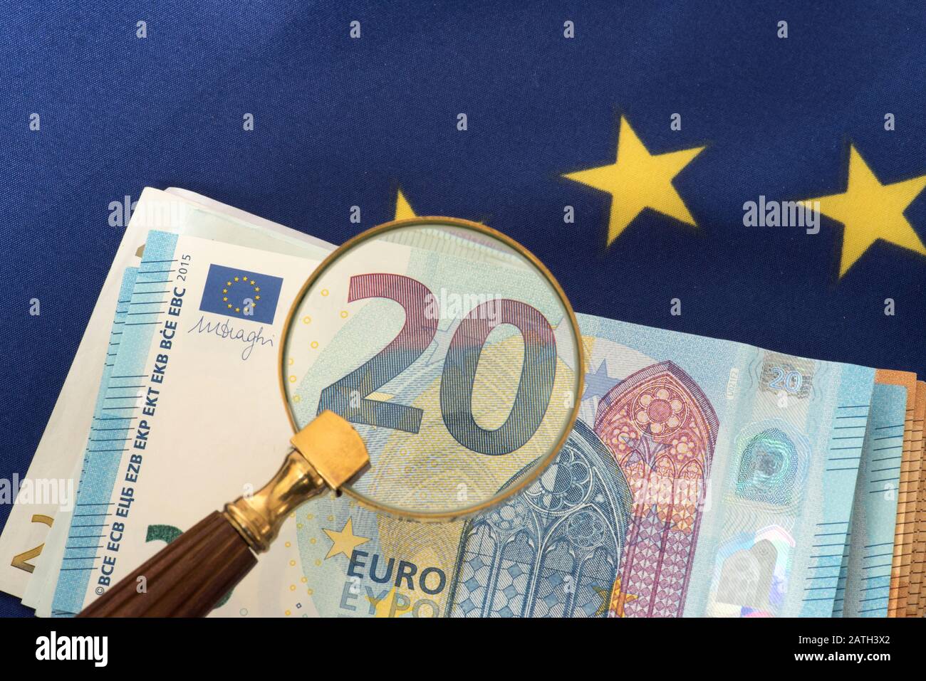 European Union flag EU, a magnifying glass and euro banknotes Stock Photo