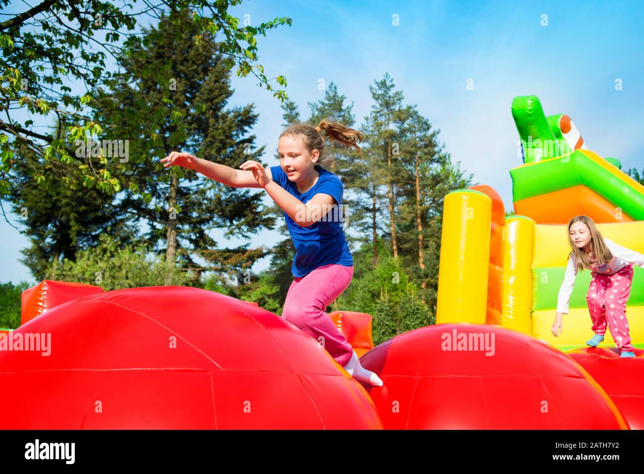 Happy little girls having lots of fun while jumping from ball to ball on an inflate castle. Stock Photo