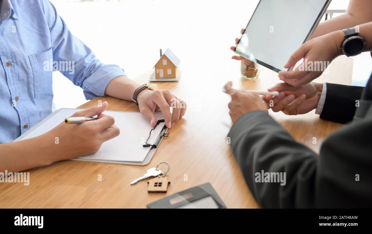 Side view of real estate agent presenting to customer with blank screen