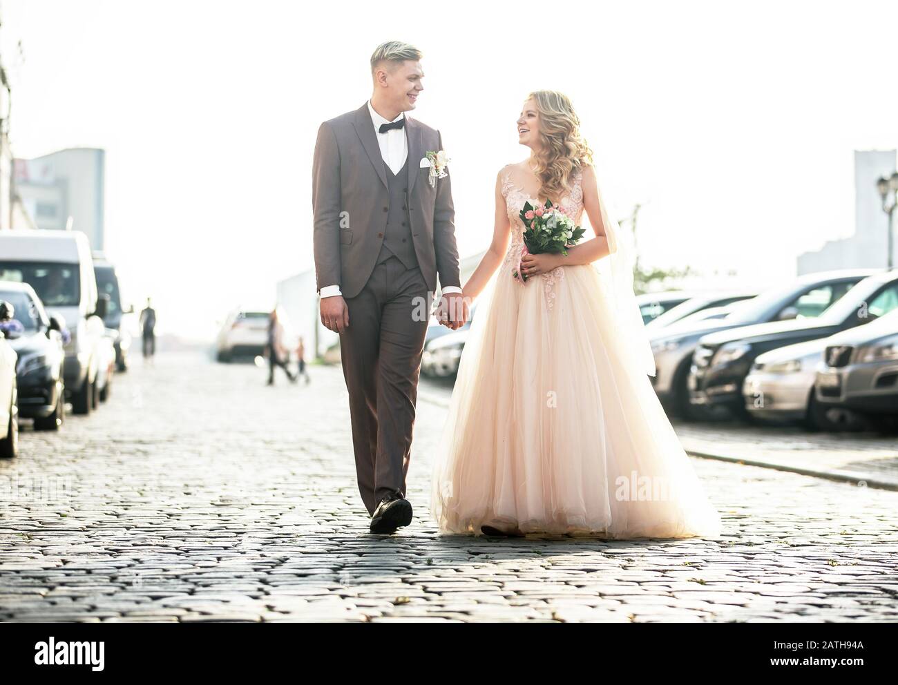 happy bride and groom walking on city street Stock Photo - Alamy