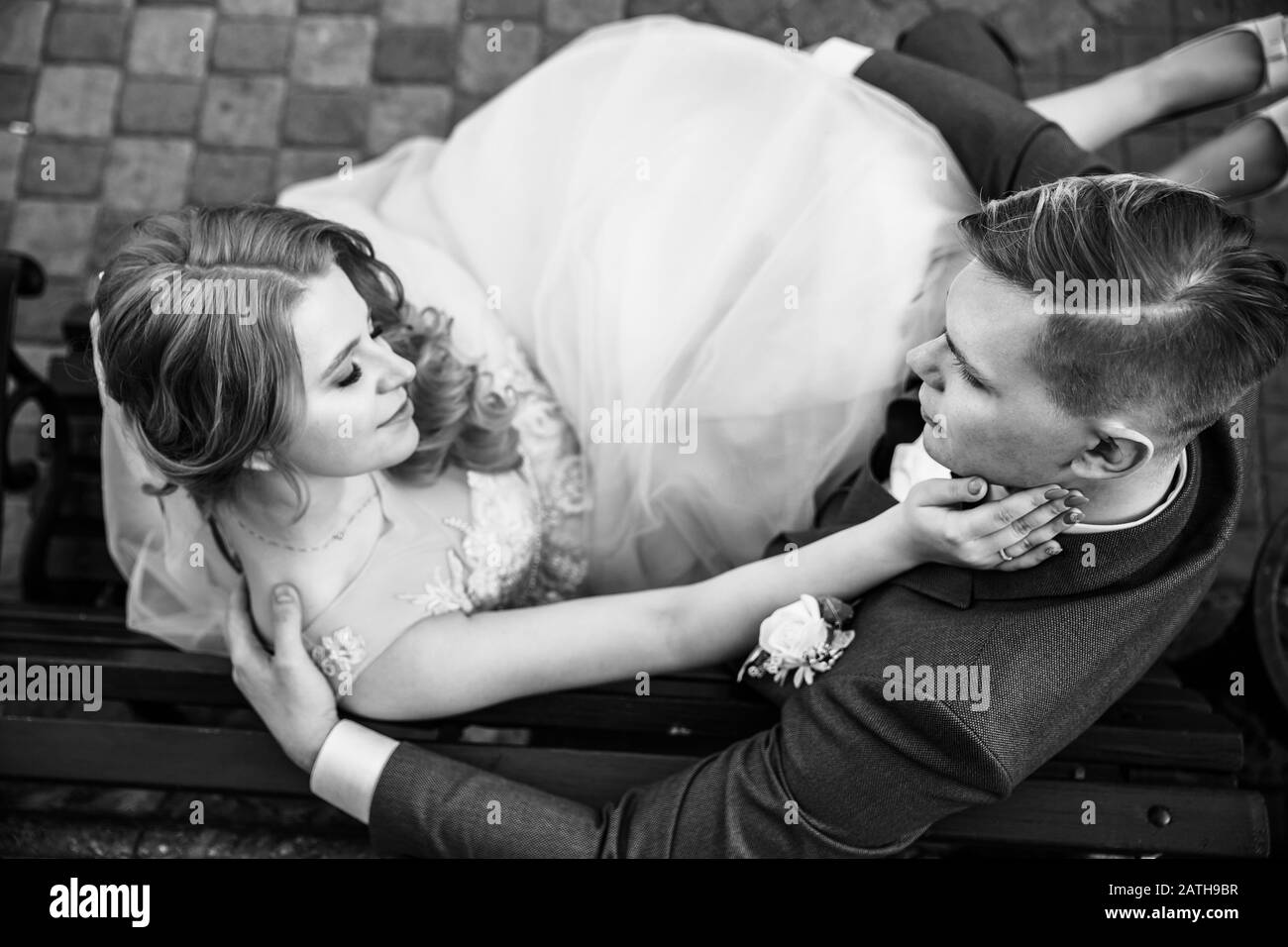 top view. happy bride and groom sitting on a bench Stock Photo - Alamy