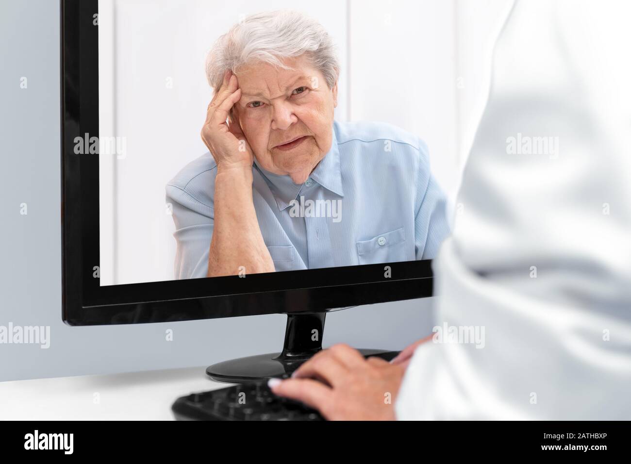 Telemedicine and e-health with a doctor and a elderly woman with afflictions, patient on the desktop Stock Photo