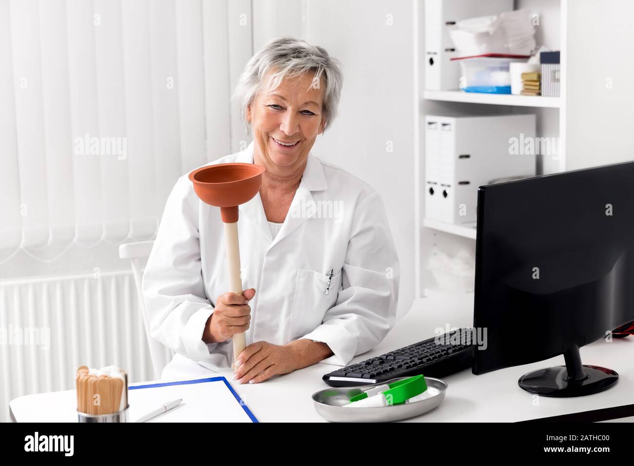 Funny concept for diarrhea or constipation, female doctor with a plunger or plumber´s helper Stock Photo