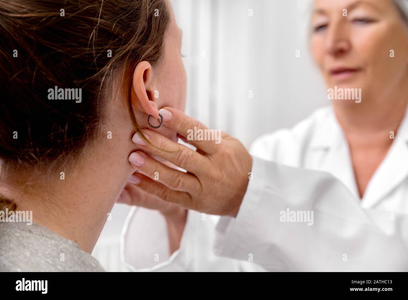 Checkup of patient´s lymph node, doctor sweeping for a flu or cold, medical office Stock Photo