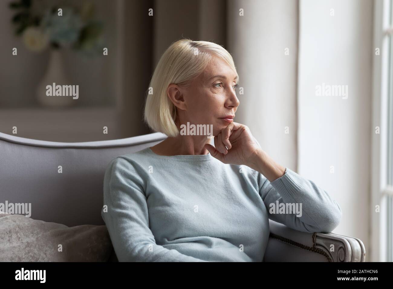 Pensive middle-aged woman look in distance thinking Stock Photo