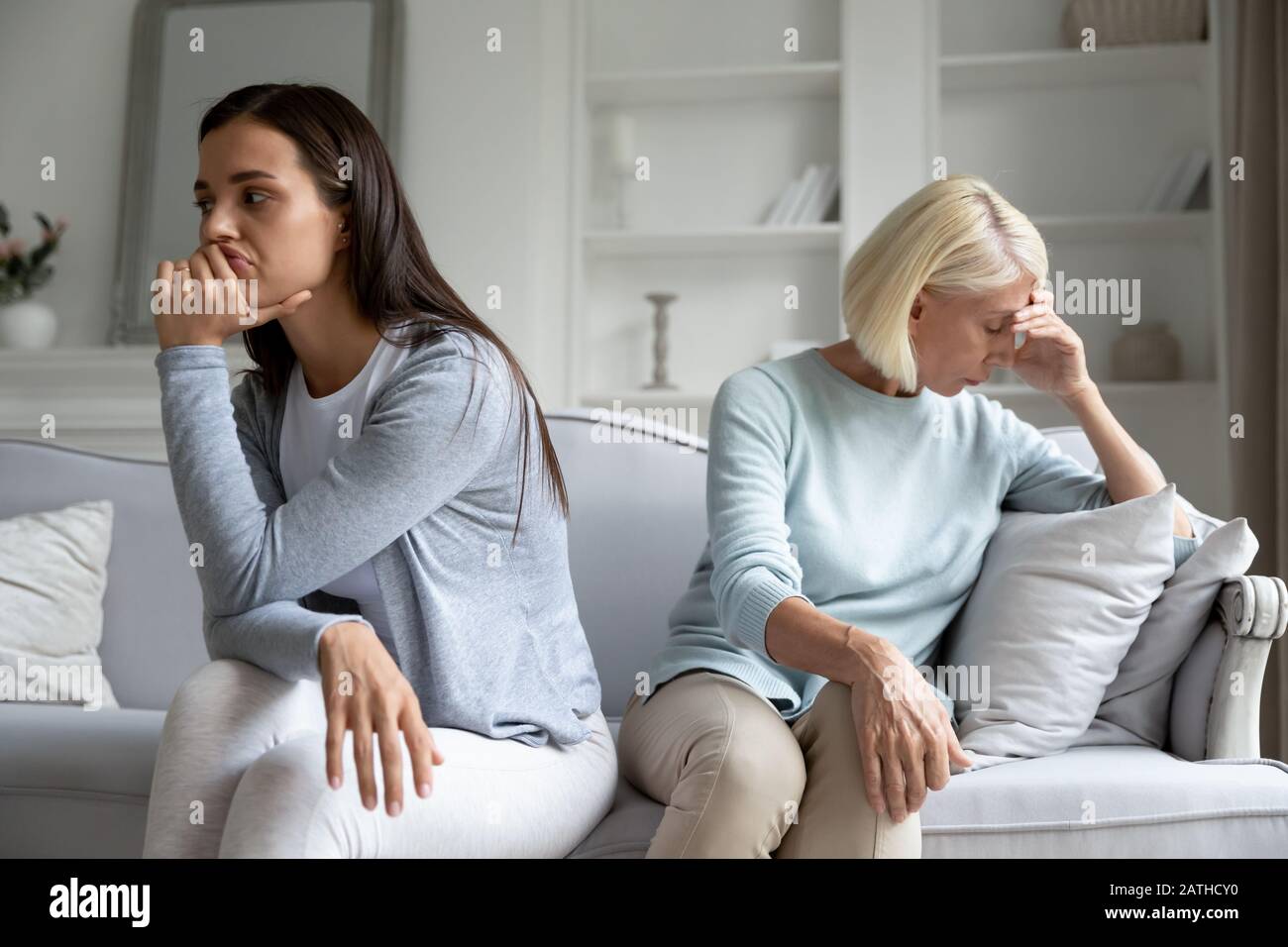 Thoughtful adult mom and daughter avoid talking after quarrel Stock Photo