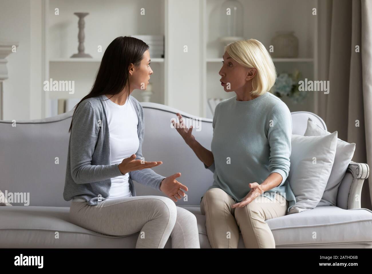 Angry grownup daughter and middle-aged mom dispute at home Stock Photo