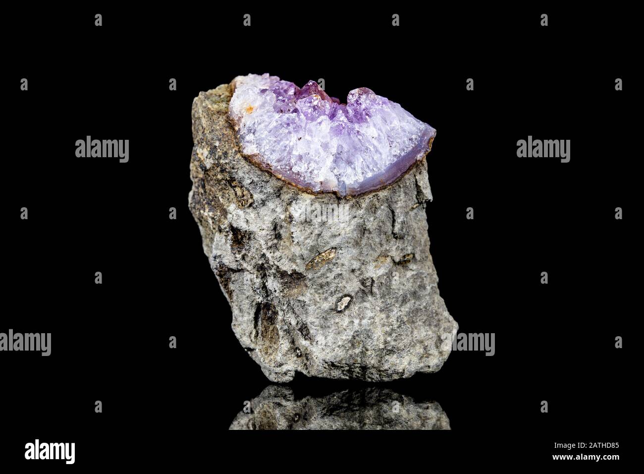 Raw amethyst mineral stone on mother rock in front of black background ...