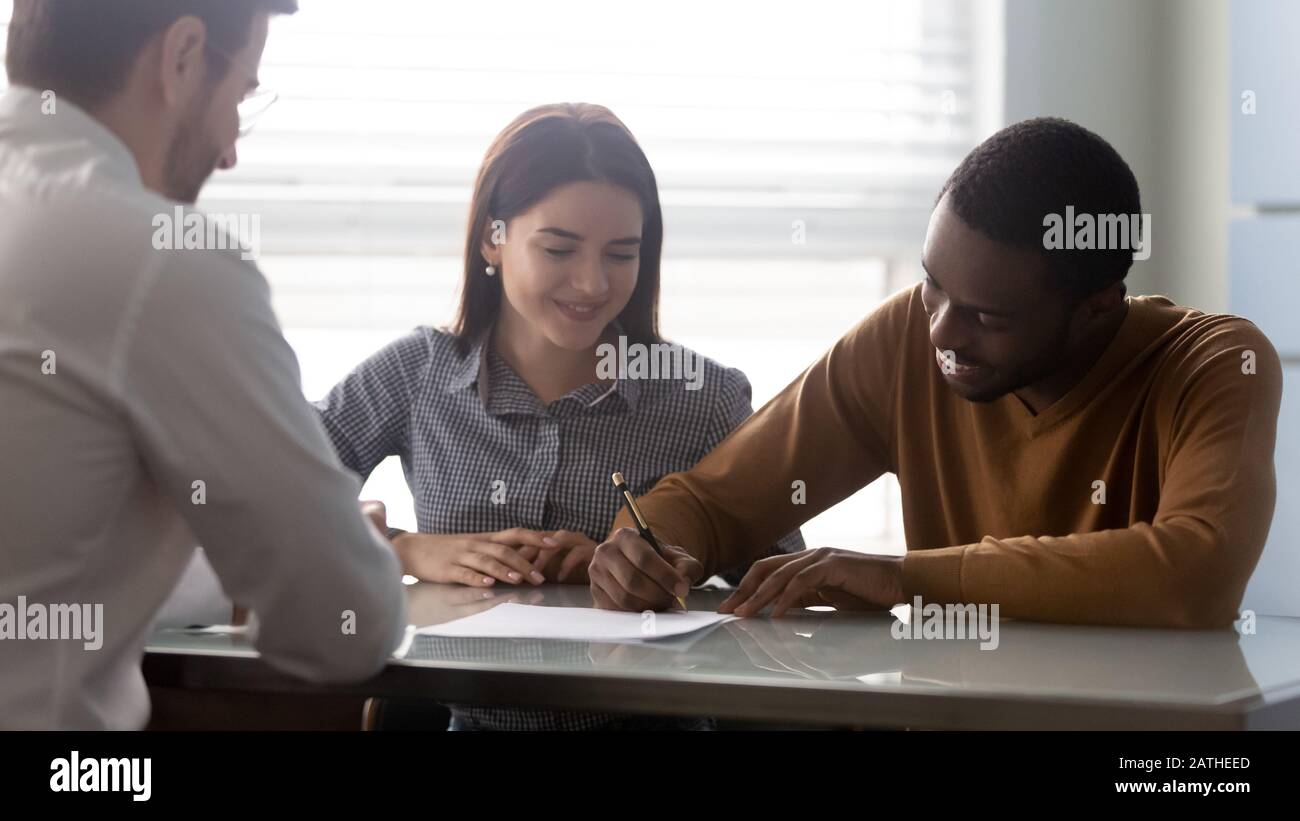 Interracial family make deal purchasing first dwelling signing contract Stock Photo