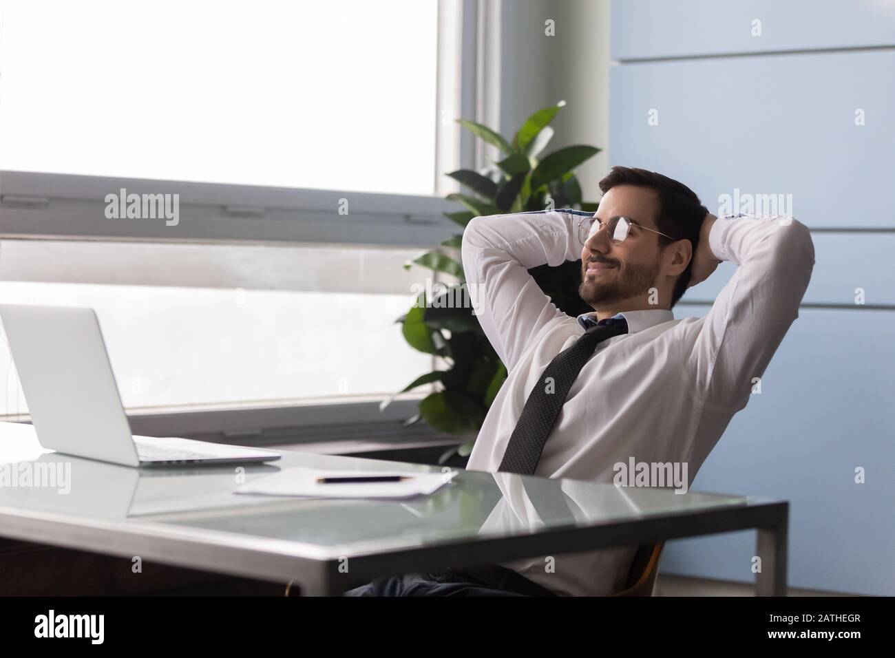 Businessman put hands behind head enjoy day off at workplace Stock Photo