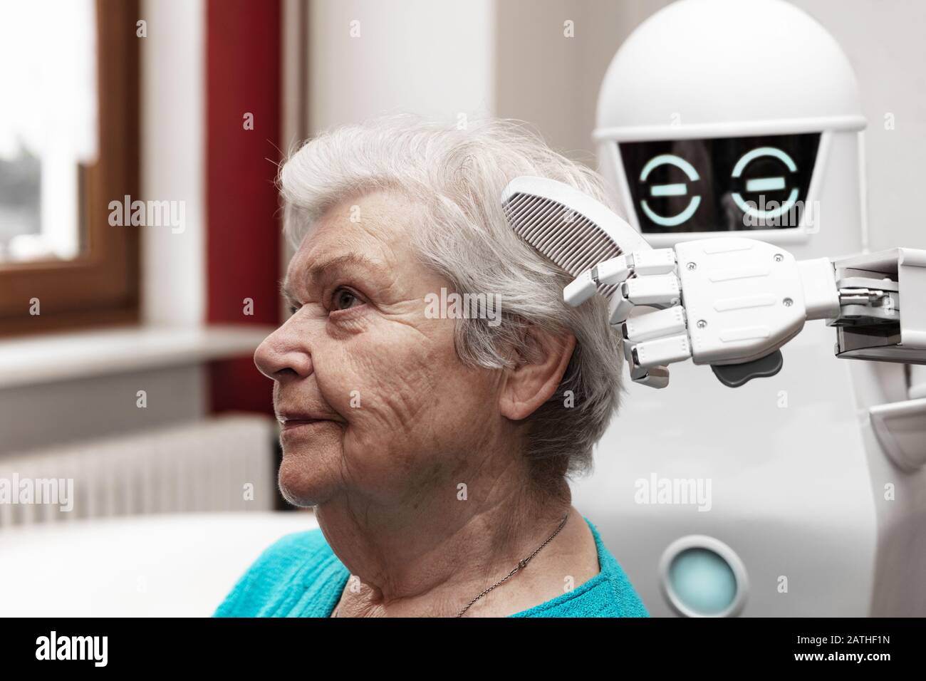 a robotic caregiver is combing the hair of a female senior adult, concepts like household nursing robot or helping technology in medicine Stock Photo