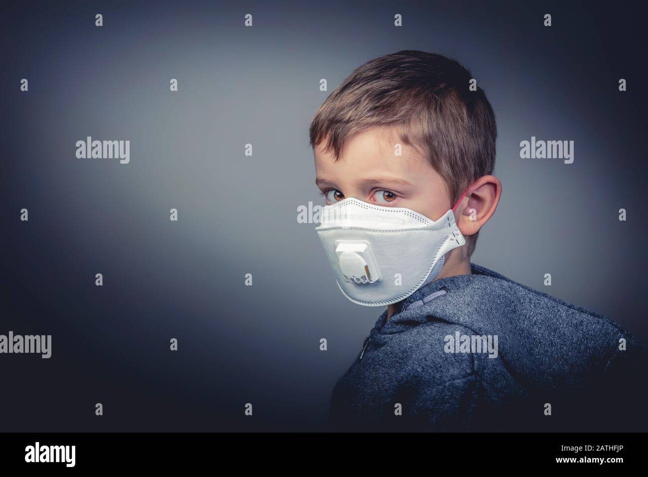 young 6 year old caucasian boy wears a protective medical mask to defend himself against the new asian crown virus. First floor, horizontal format. he Stock Photo