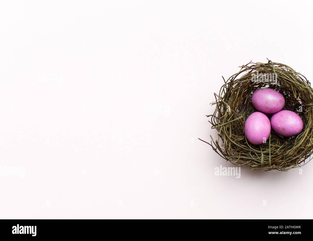 Pink Easter Eggs in a nest with a colourful background Stock Photo