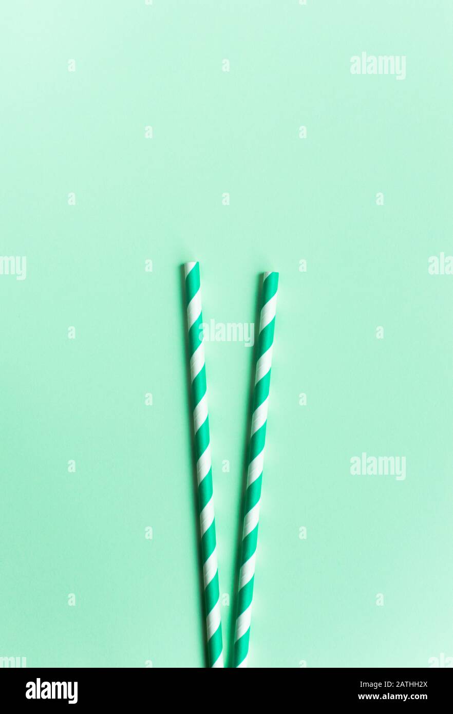 Green paper straws on a green background Stock Photo