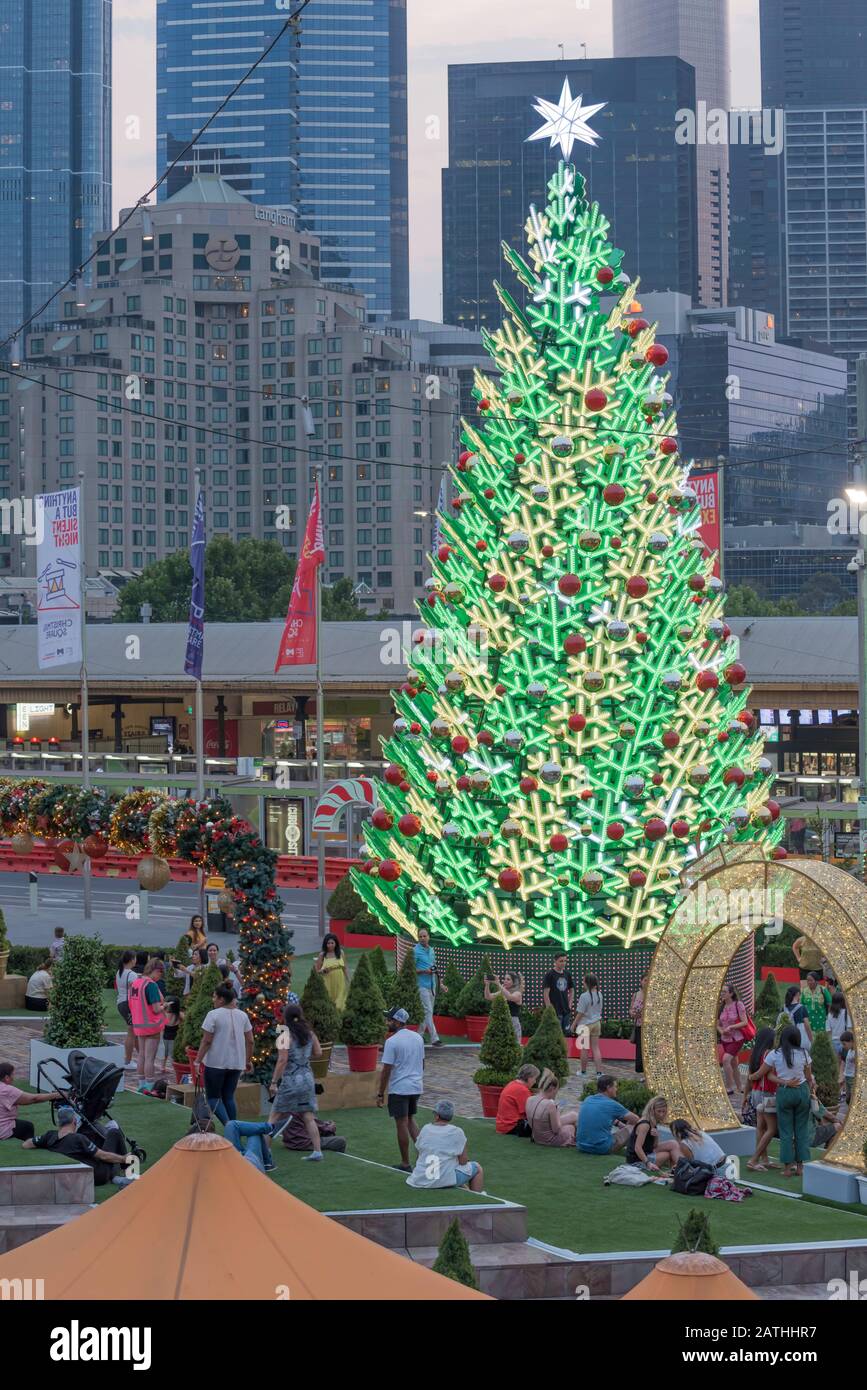 Dec 2019: Early evening and Christmas decorations along with a large lit up Christmas tree in Federation (Fed) Square in central Melbourne, Australia Stock Photo