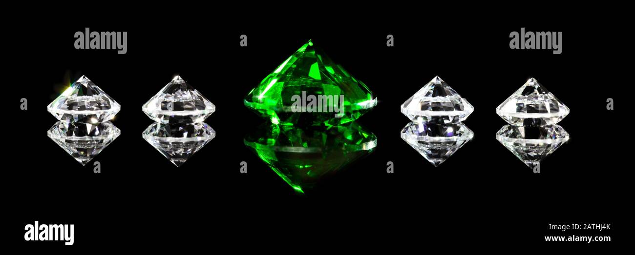 Panorama, diamonds and a green emerald in front of black background, closeup Stock Photo