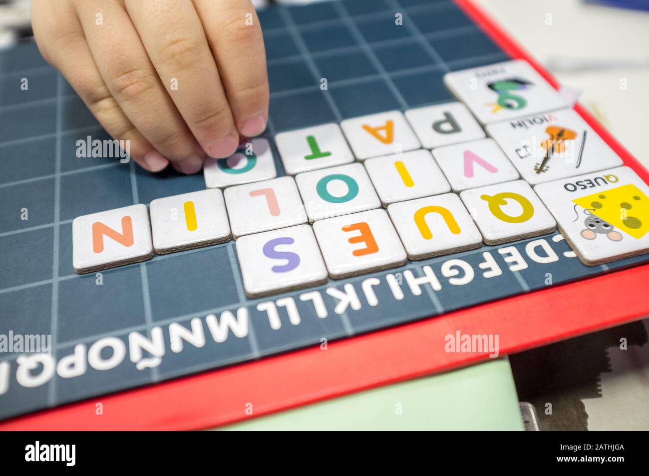 Child practices with word formation board game. The game is made with magnetic letter pieces. Selective focus Stock Photo