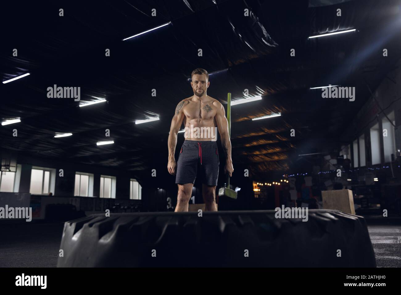 Young healthy man, athlete doing balance exercises in gym. Single model  practicing hard, training hummer slam with the tire. Concept of healthy  lifestyle, sport, fitness, bodybuilding, wellbeing Stock Photo - Alamy