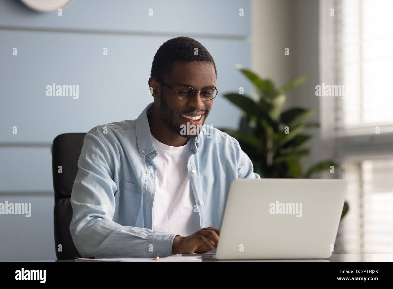 African freelancer do remote job typing message on laptop Stock Photo