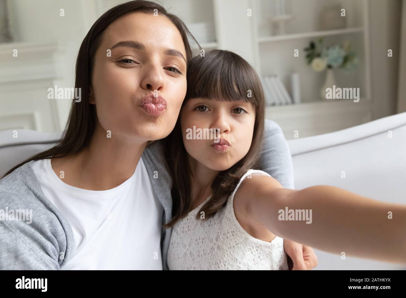 Funny young mom and preschooler daughter make selfie together Stock Photo