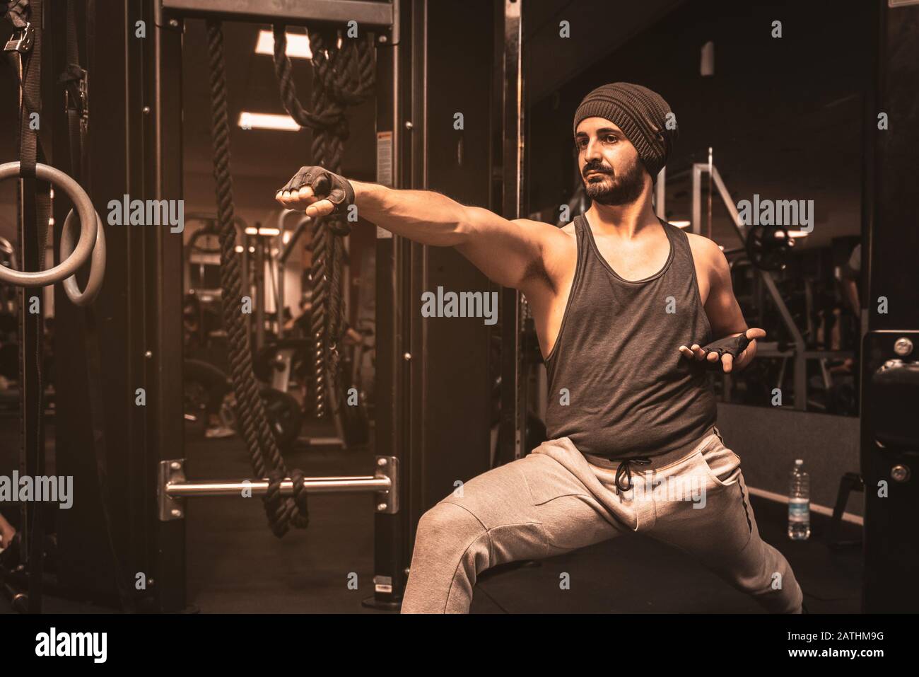 A bearded sporty man in the gym is doing Yoga and Martial Arts