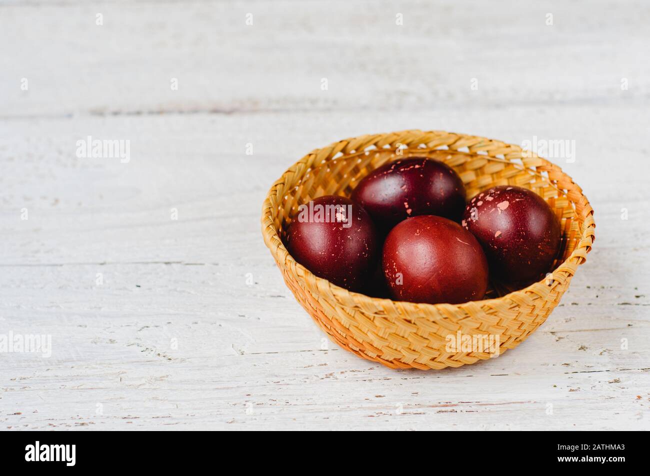 Old fashioned colored easter eggs in straw basket Stock Photo